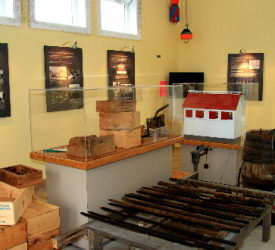 Exposition de boîtes en bois et d'un vieux gril au Musée de la boucanière