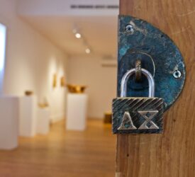 A lock with the AX: Arts & Culture Centre of Sussex logo on it